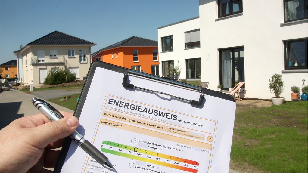 Ein Energieausweis ist vor modernen Einfamilienhäusern in Berlin-Karlshorst zu sehen.