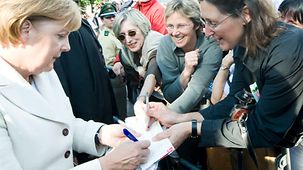 Bundeskanzlerin Merkel gibt Autogramme