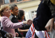 Chancellor Angela Merkel and US President Barack Obama shake hands with the crowd