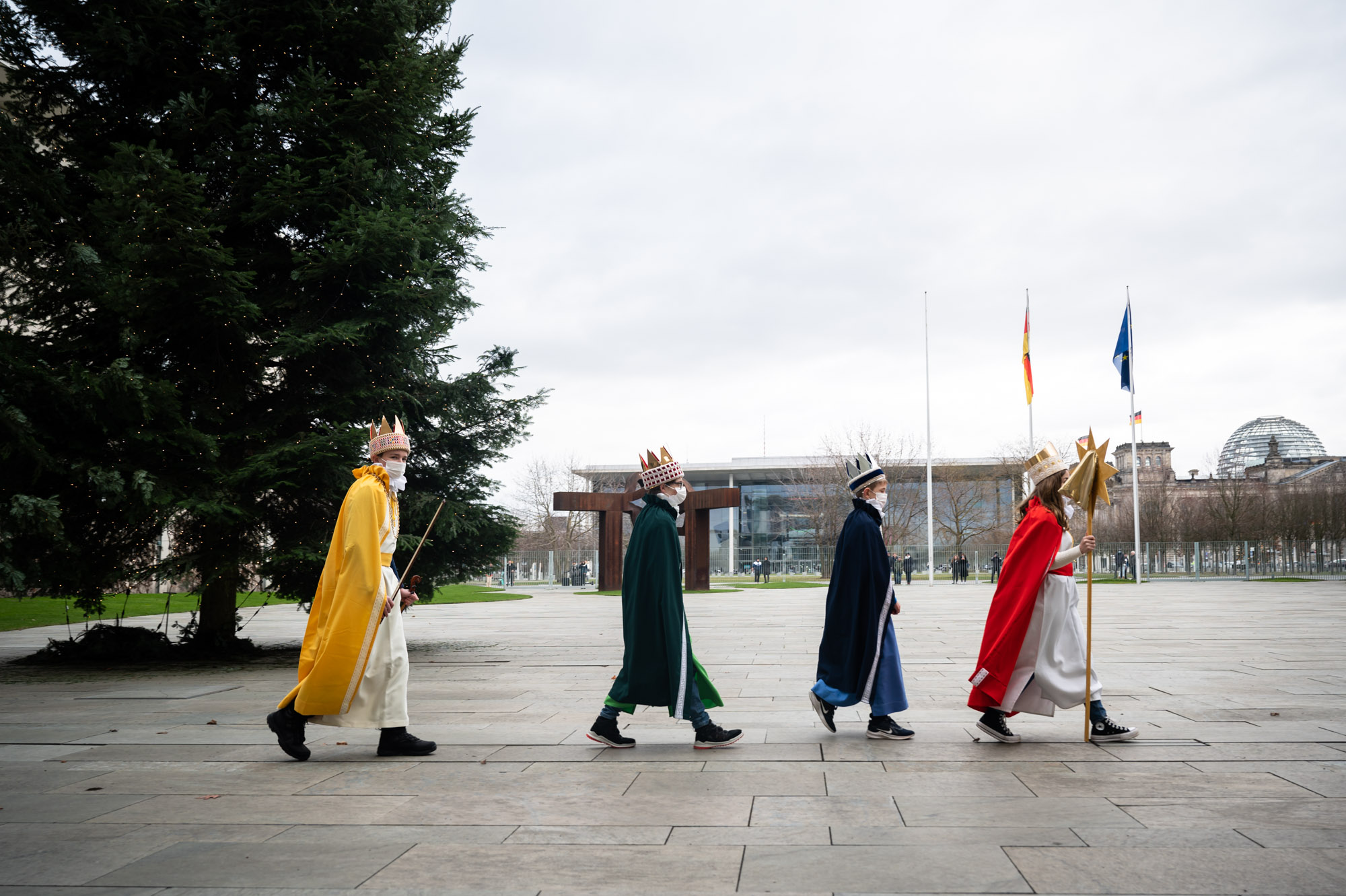 Sternsinger gehen nacheinander im Bundeskanzleramt.