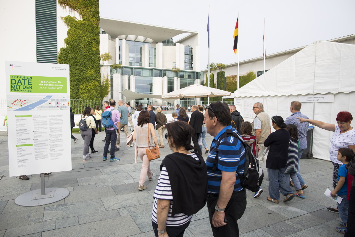 Besucher informieren sich beim Tag der offenen Tür im Kanzleramt an einer Informationstafel.