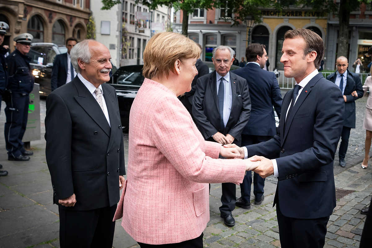 Chancellor Angela Merkel greets French President Emmanuel Macron in Aachen.