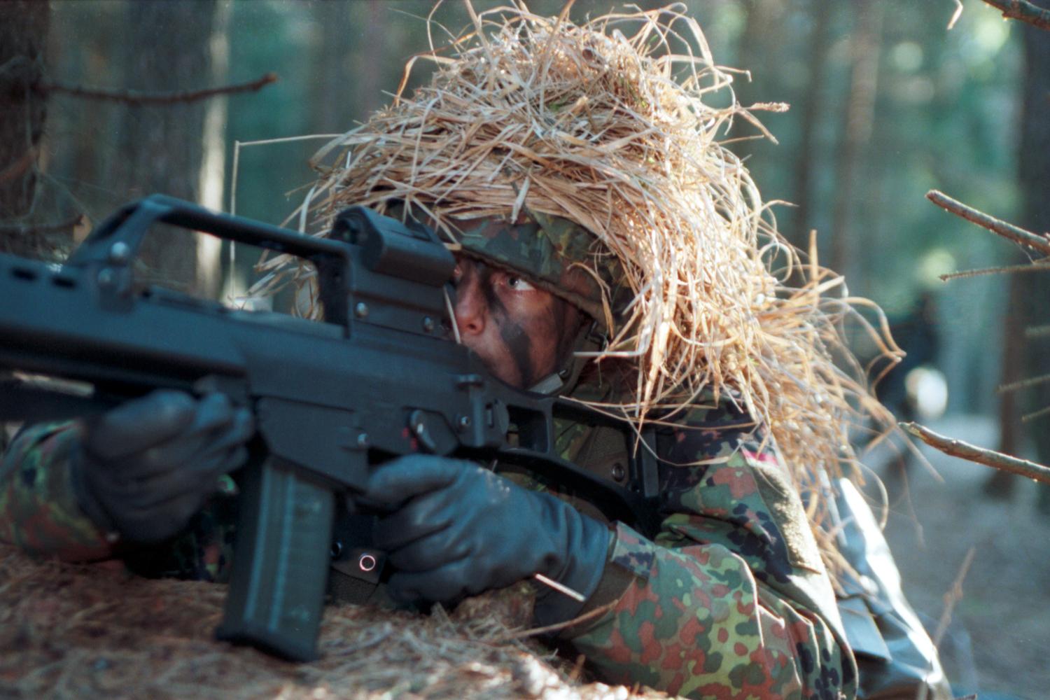 A female soldier aiming a G36 assault rifle