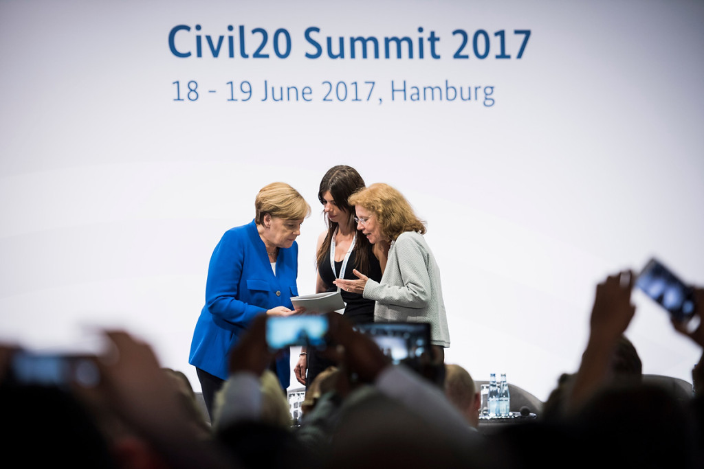 Chancellor Angela Merkel is presented with the Civil20 recommendations.