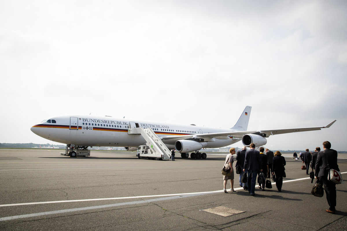 Journalists walk towards an airplane at Tegel airport