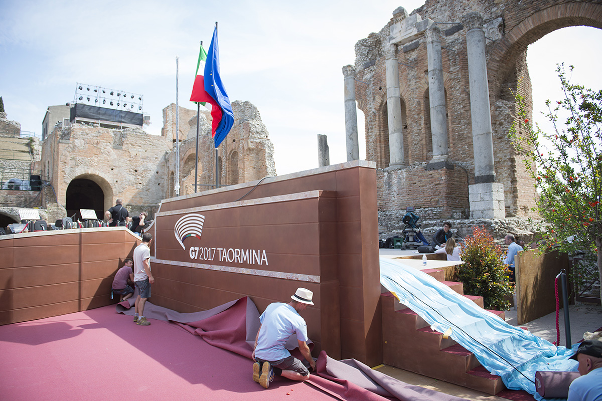 Des travailleurs installent un tapis en prévision du sommet du G7
