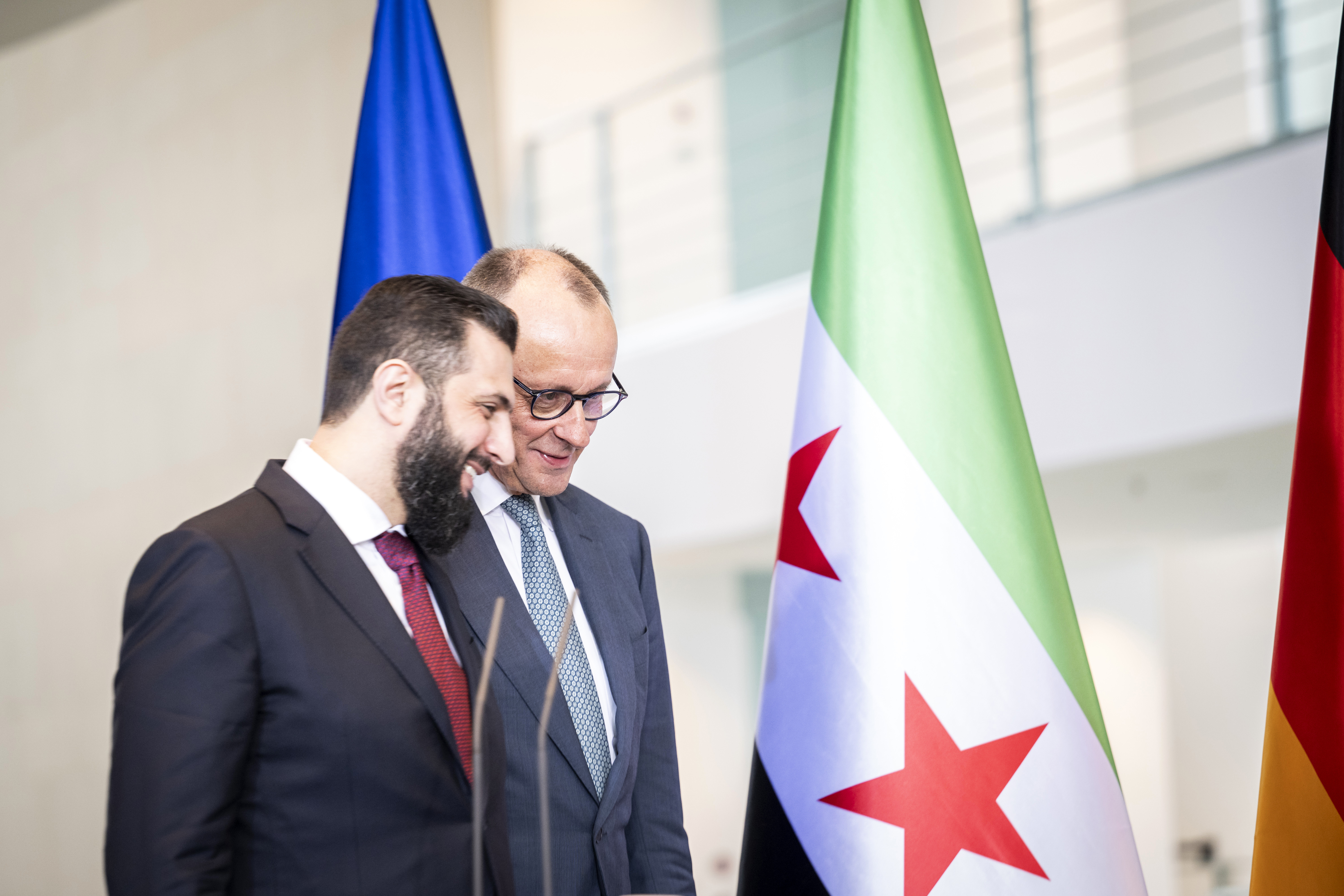 Bundeskanzler Merz und Ahmed Al-Scharaa sprechen locker miteinander.