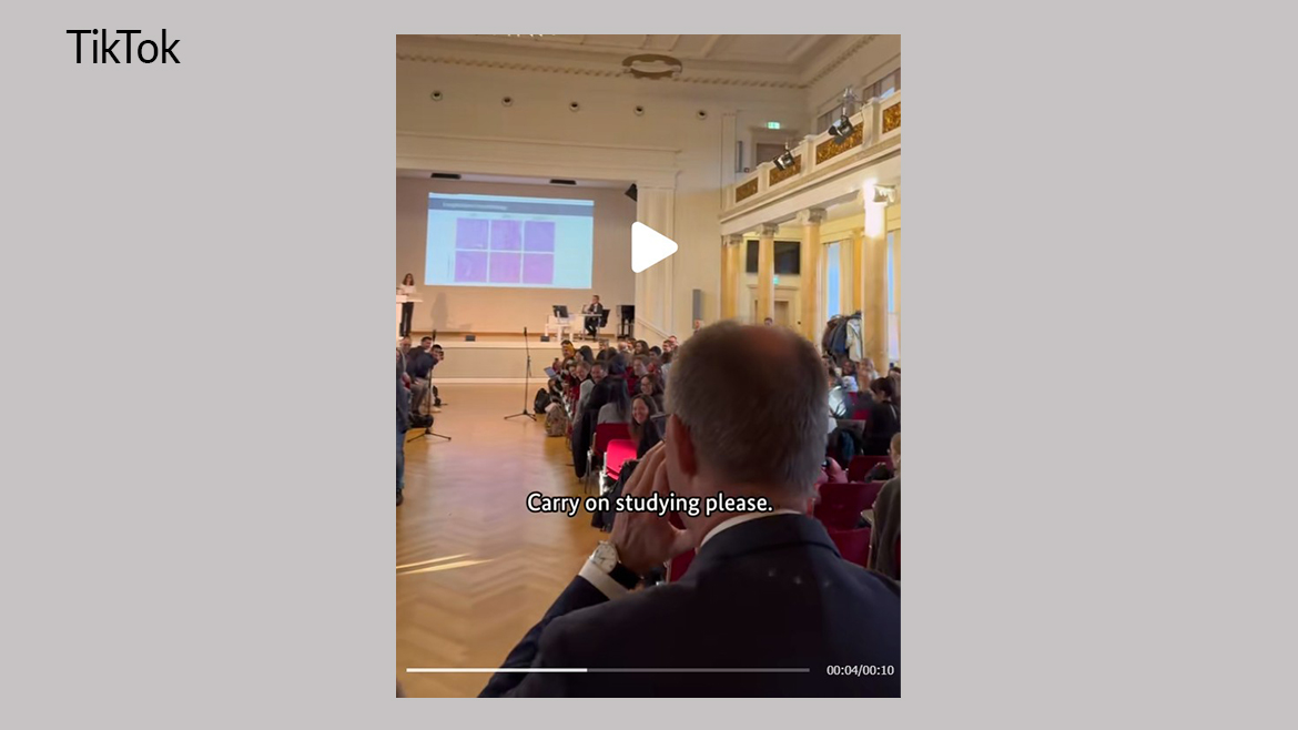 Bundeskanzler Merz betritt einen Hörsaal mit Studierenden