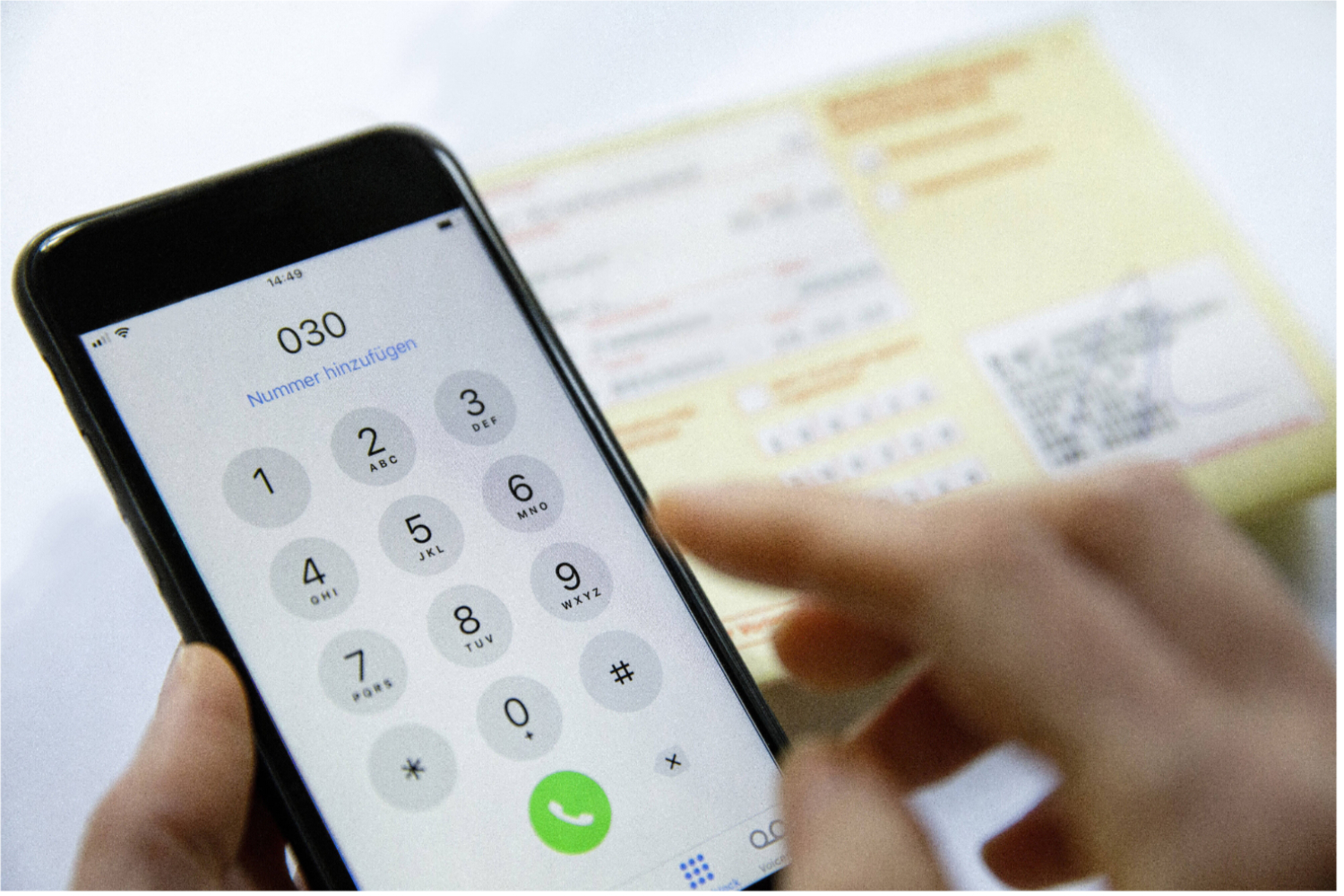 Ein Mobiltelefon und ein Krankenschein