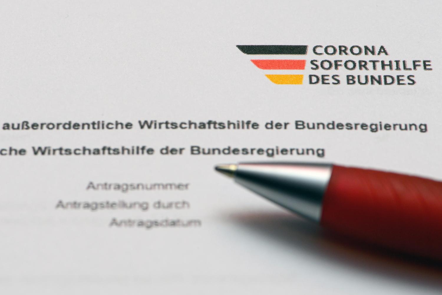 Ein Stift liegt auf einem Antragsformular für Corona-Hilfen des Bundes