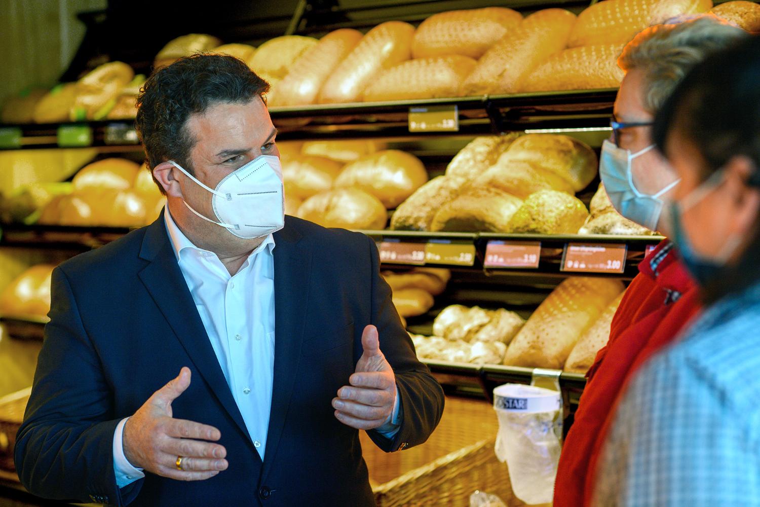 Hubertus Heil (SPD), Bundesminister für Arbeit und Soziales spricht in einer Bäckerei mit Mitarbeitern.