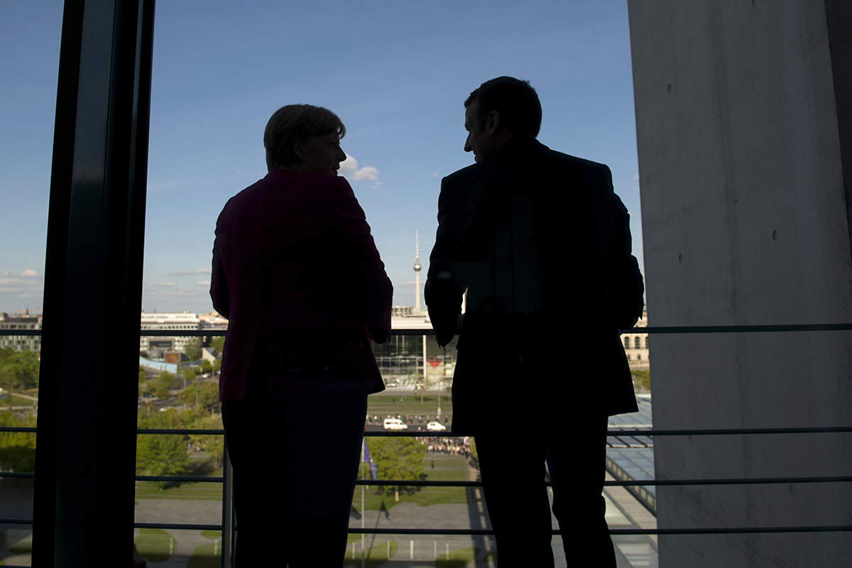 Bundeskanzlerin Angela Merkel spricht mit Frankreichs Präsident Emmanuel Macron auf einer Terrasse im Bundeskanzleramt.