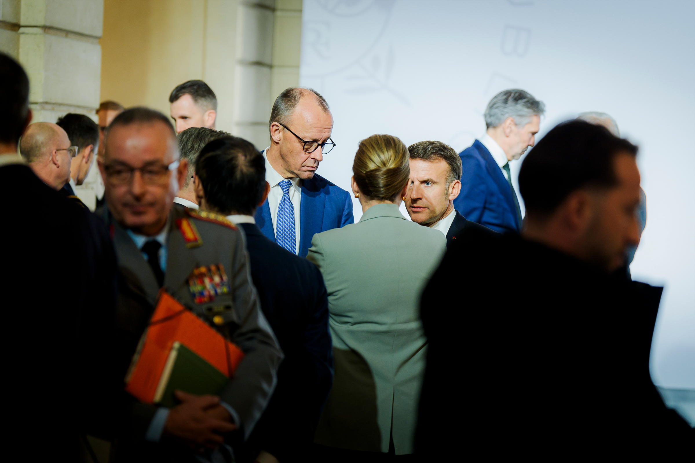 Das Foto zeigt Bundeskanzler Friedrich Merz im Gespräch mit Emmanuel Macron, Frankreichs Präsident, und Mette Frederiksen, Dänemarks Premierministerin, bei einem Treffen der "Koalition der Willigen"