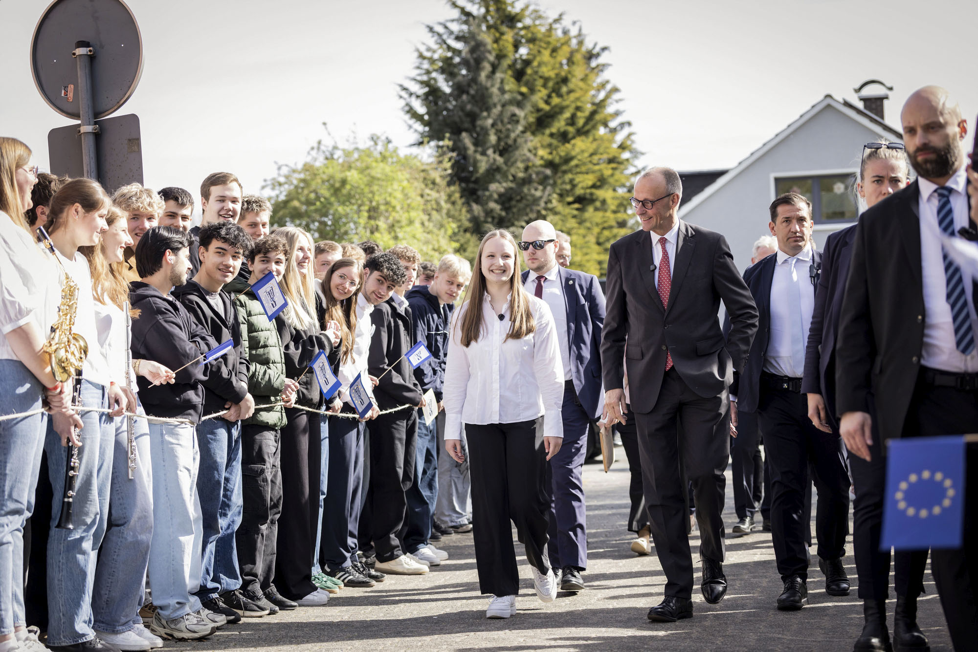 Bundeskanzler Friedrich Merz wird bei der Ankunft am Carolus-Magnus-Gymnasium von Schülerinnen und Schülern begrüßt.