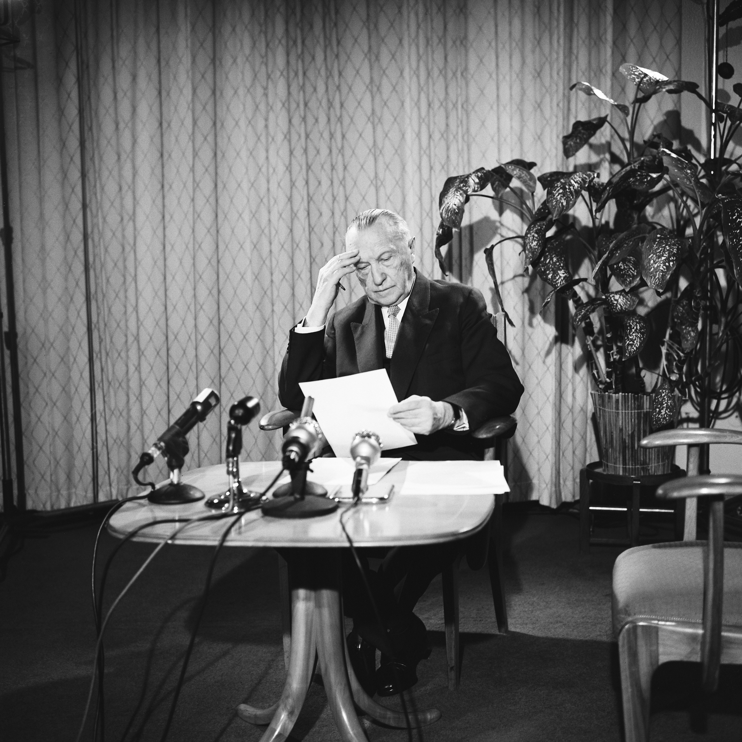 Schwarz-weiß-Fotografie zeigt Bundeskanzler Konrad Adenauer mit Redemanuskript vor Mikrofonen, Aufnahme aus dem Jahr 1959