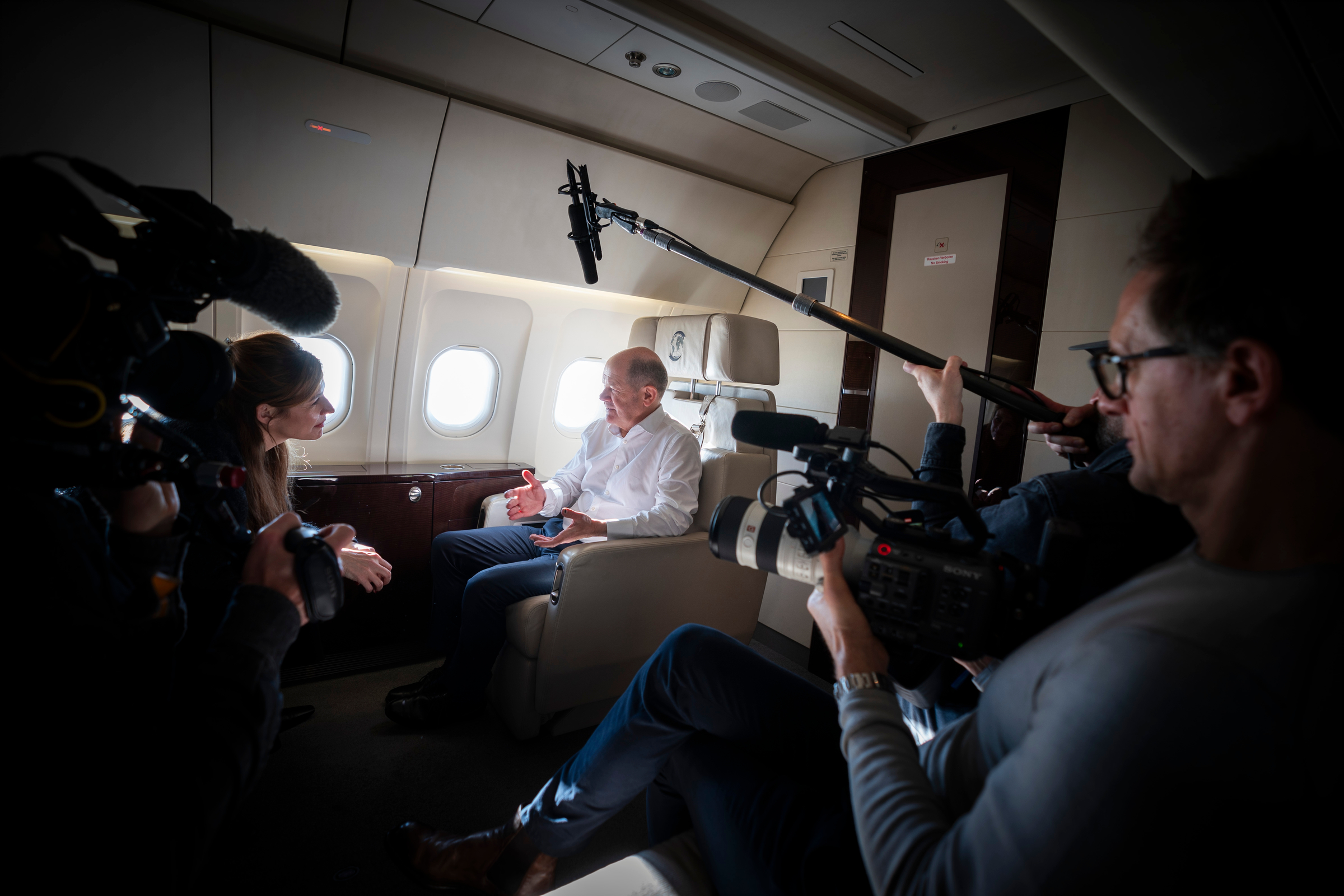 Bundeskanzler Olaf Scholz bei einem Interview in einem Flugzeug 