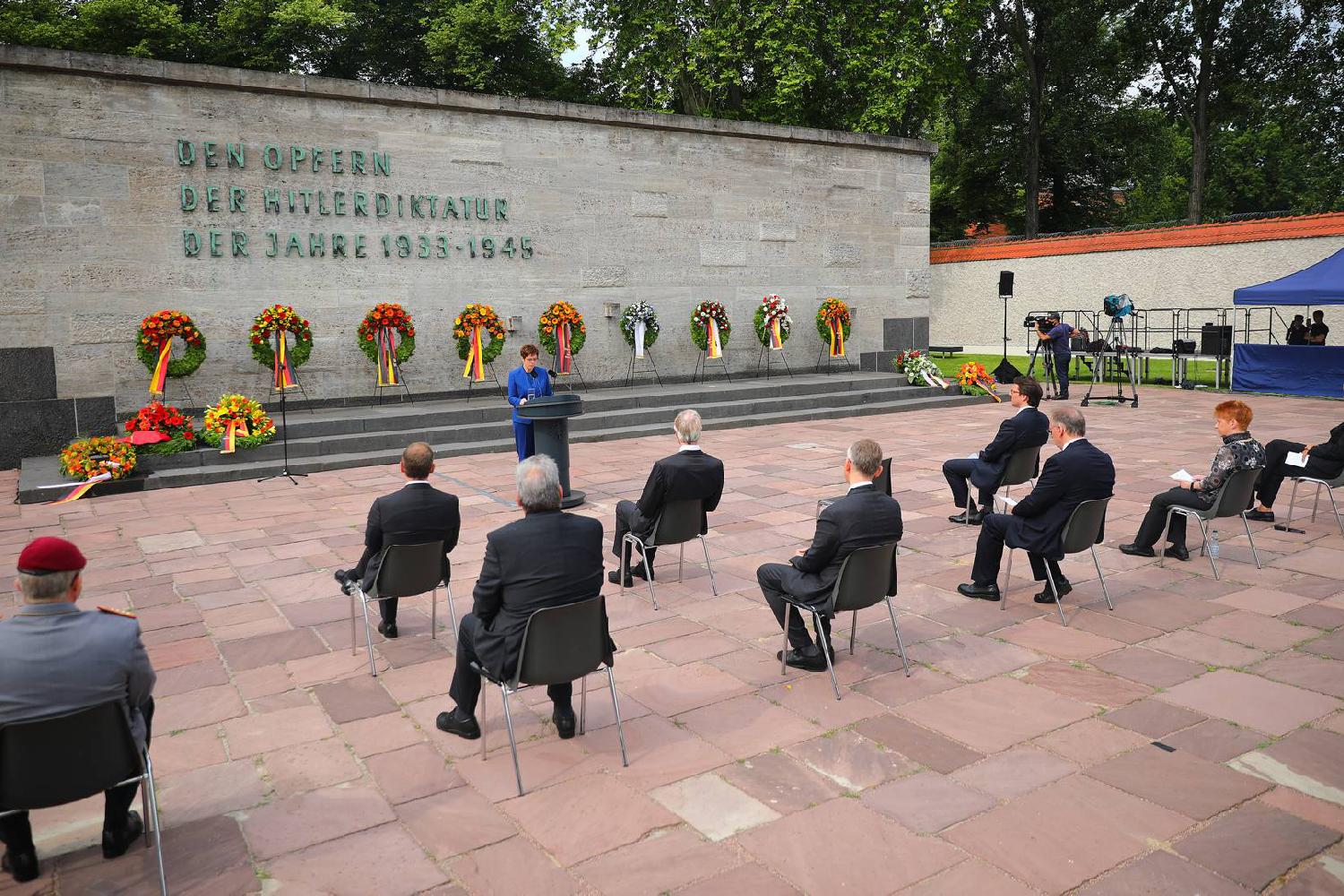 Commémoration du 20 juillet 1944 : la ministre fédérale de la Défense Annegret Kramp-Karrenbauer tient un discours. Derrière elle, l'on peut voir quatre gerbes.