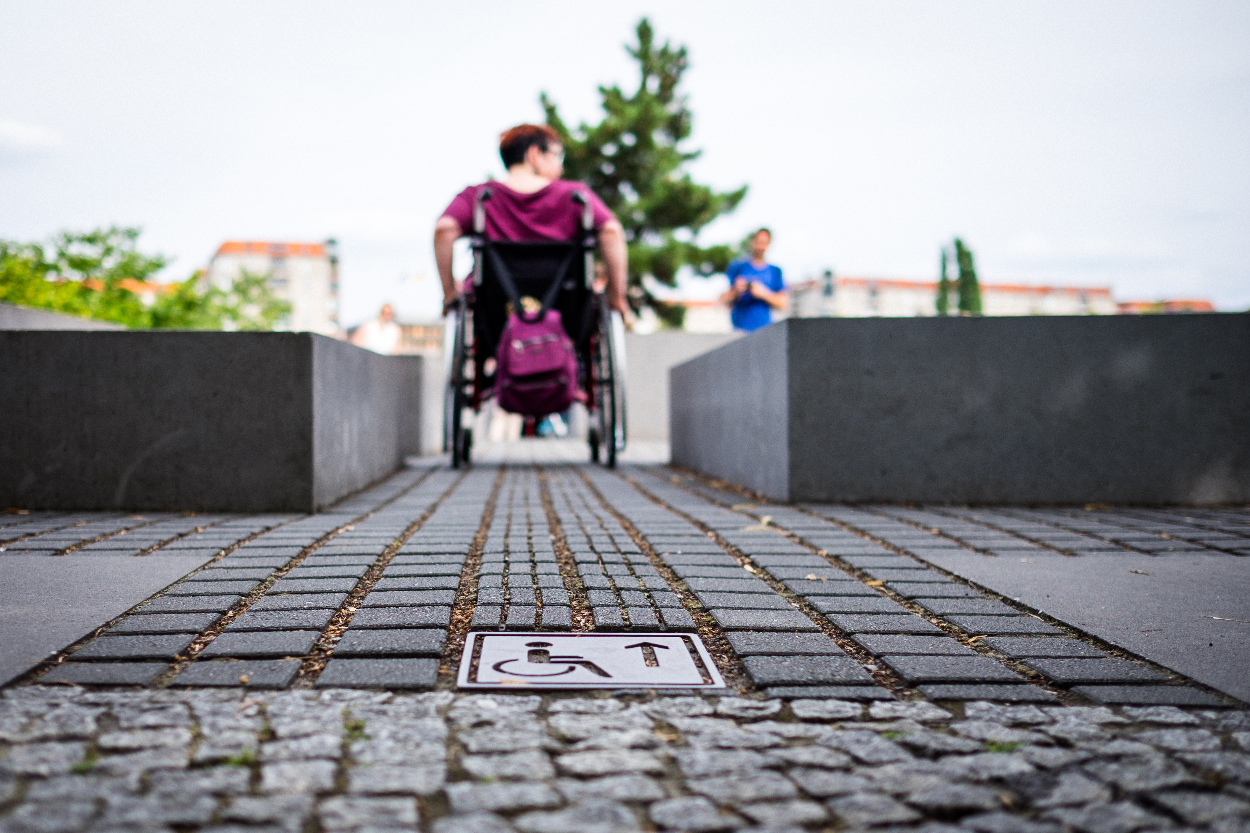 Une femme en fauteuil roulant se fraye un chemin entre deux obstacles