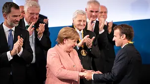 Chancellor Angela Merkel congratulates French President Emmanuel Macron on being awarded the Charlemagne Prize.