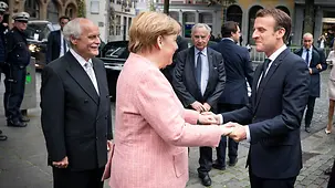 Chancellor Angela Merkel greets French President Emmanuel Macron in Aachen.