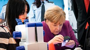 Bundeskanzlerin Angela Merkel mit Mädchen beim Girls' Day im Bundeskanzleramt am Stand der Bundespolizei.