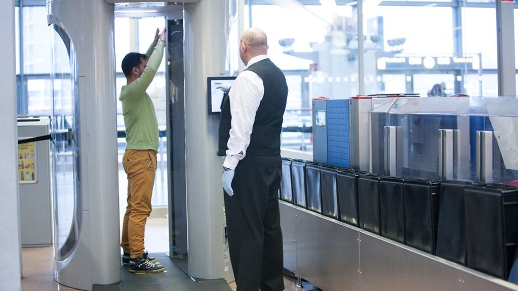 Ein Mann steht am Flughafen Hamburg in einem Körperscanner.