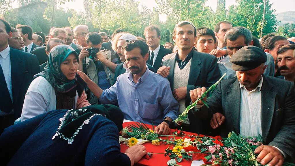 Family members lay flowers on the coffins.