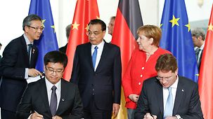 Bundeskanzlerin Angela Merkel und Li Keqiang, Chinas Premierminister, beobachten deutsch-chinesische Vertragsunterzeichnungen.