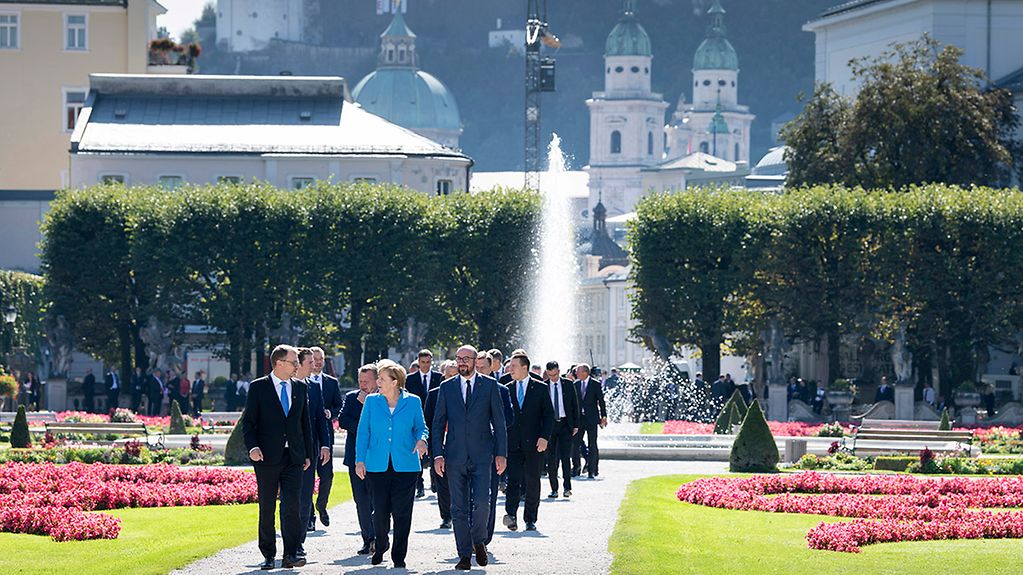 The EU heads of state and government walk through the gardens of Mirabell Palace.