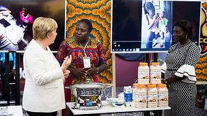 Chancellor Angela Merkel deep in conversation during a visit to the Impact Hub Accra