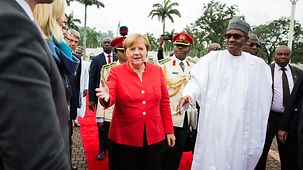 Chancellor Angela Merkel is welcomed by Muhammadu Buhari, Nigeria's President.