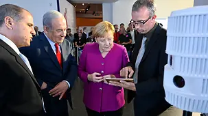 Bundeskanzlerin Angela Merkel und Israels Premierminister Benjamin Netanjahu an einem Informationsstand.
