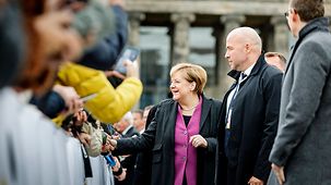 Bundeskanzlerin Angela Merkel schüttelt Hände von Bürgerinnen und Bürgern anlässlich des Tags der Deutschen Einheit.