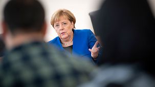 Bundeskanzlerin Angela Merkel spricht mit Teilnehmern einer Rechtsstaatsklasse.