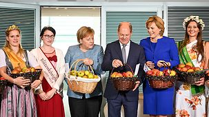 Bundeskanzlerin Angela Merkel mit einem Korb voll Äpfeln während des Apfelkabinetts.