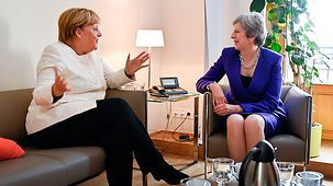 Chancellor Angela Merkel in discussion with British Prime Minister Theresa May on the sidelines of a European Council meeting.