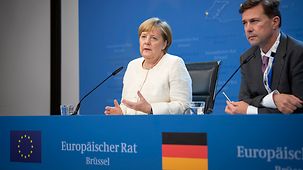 Chancellor Angela Merkel speaks at a press conference on the meeting of the European Council; beside her sits Steffen Seibert, federal government spokesperson.