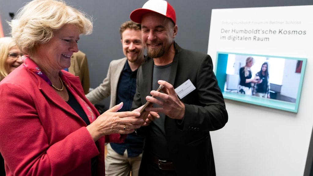 Kulturstaatsministerin Grütters hält ein Tablet in der Hand.