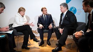 Bundeskanzlerin Angela Merkel im Gespräch mit der ukrainische Präsident Petro Poroschenko und Frankreichs Präsident Emmanuel Macron.