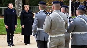 Chancellor Angela Merkel stands next to French President Emmanuel Macron at the celebration to commemorate the end of the First World War.