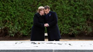 Chancellor Angela Merkel and French President Emmanuel Macron unveil a commemorative plaque.