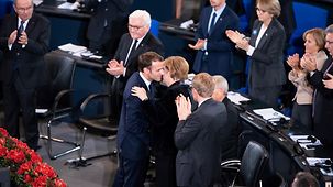 Frankreichs Präsident Emmanuel Macron umarmt im Bundestag nach seiner Rede Bundeskanzlerin Angela Merkel.