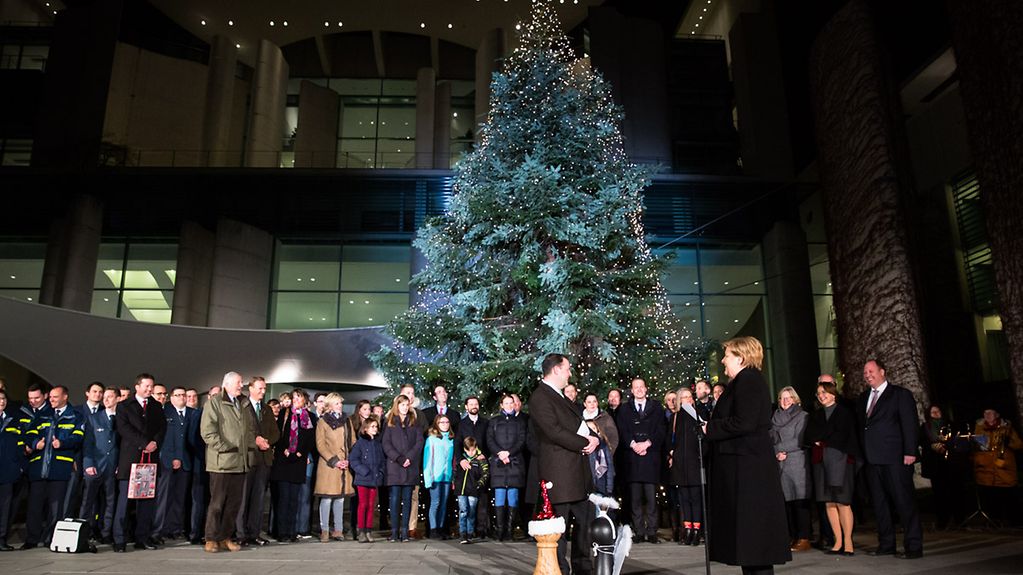 Kanzlerin Merkel nimmt den Weihnachtsbaum vor dem Kanzleramt entgegen.