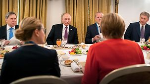 Angela Merkel speaks with Vladimir Putin.