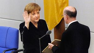Bundeskanzlerin Angela Merkel wird 2005 im Deutschen Bundestag durch Bundestagspräsident Norbert Lammert vereidigt.