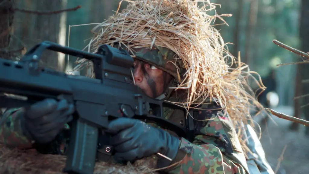 A female soldier aiming a G36 assault rifle