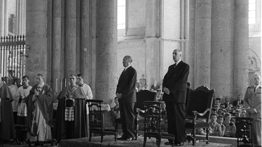 Bundeskanzler Konrad Adenauer und der französische Präsident Charles de Gaulle stehen neben einander in der Kathedrale von Reims.