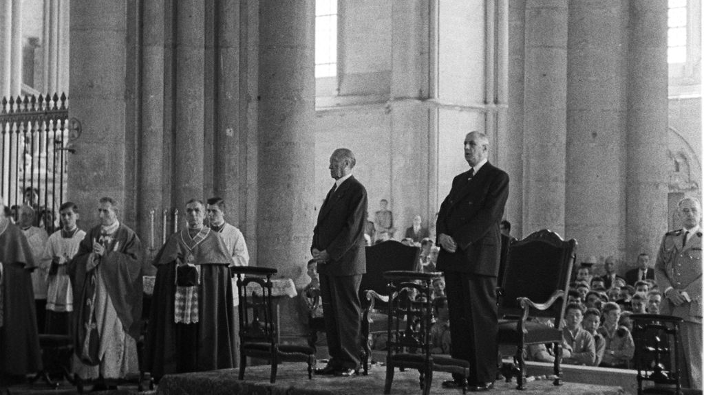 Chancellor Konrad Adenauer and French President Charles de Gaulle stand together in Reims Cathedral.