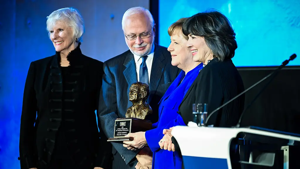 Chancellor Merkel holds the award in her hand 