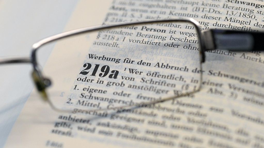 Gesetzestext zum Paragrafen 219a durch ein Brillenglas betrachtet.